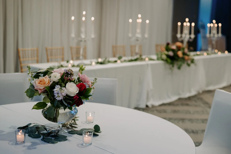 a table with a vase of flowers and candles on it