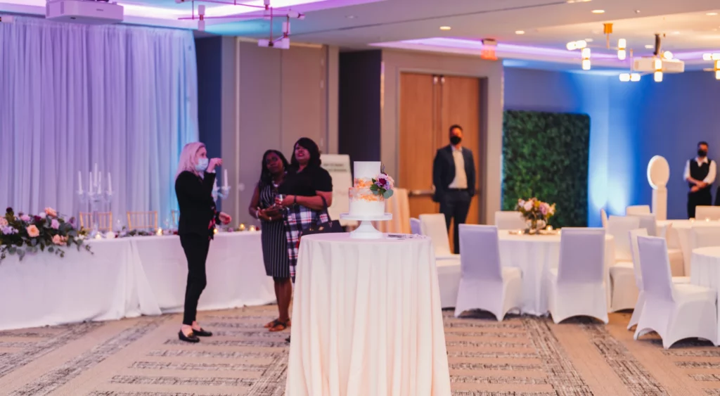 a group of people standing around a table with a cake on it